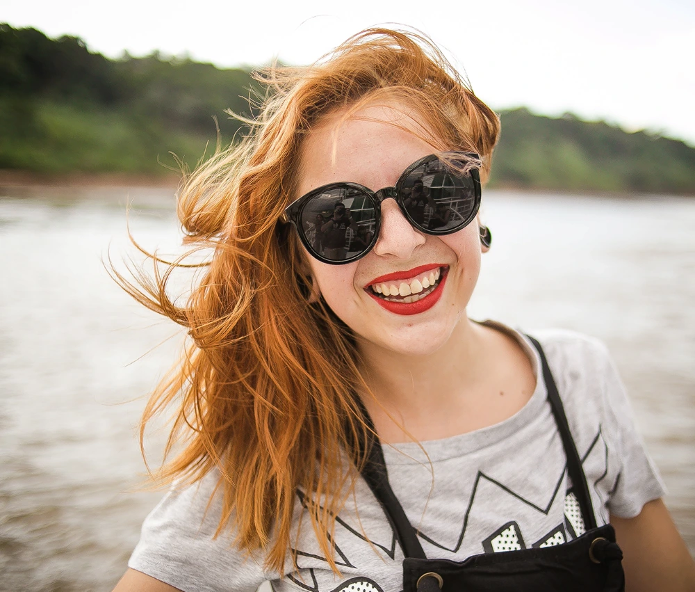 a woman smiling and wearing shades