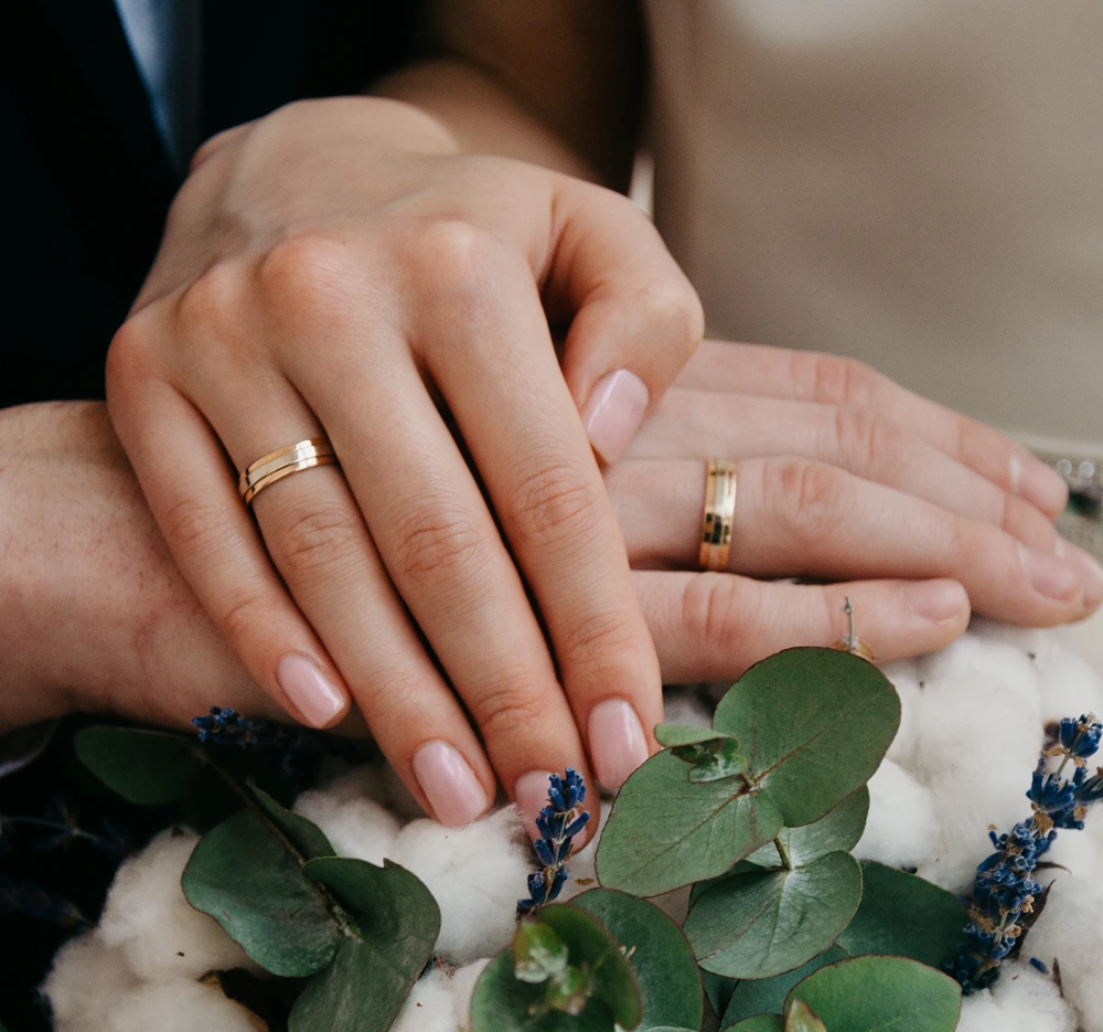 Two hands wearing their wedding rings
